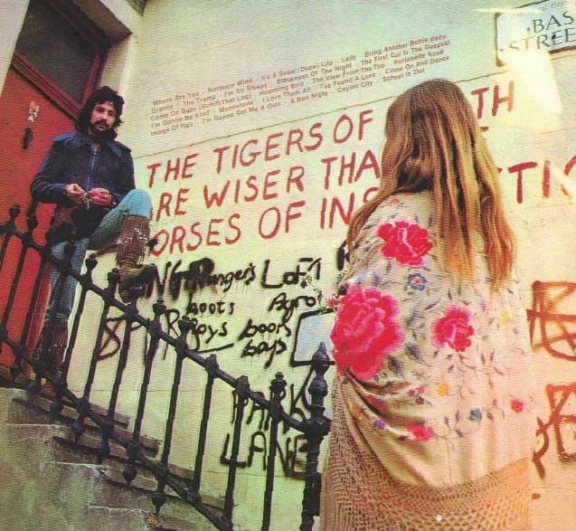 Cat Stevens photographed by the William Blake graffiti "The tigers of wrath are wiser than the horses of instruction" on the corner of Lancaster Road and Basing Street in London (1970).