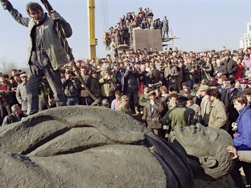 Crowd observes crew of workers tearing down Lenin statue. Bucharest, March 5th, 1990.